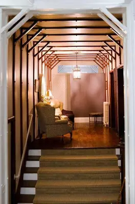 a hallway with a staircase with a chair and a couch at Lakehurst Estate in Cobourg