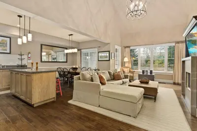 a living room with a couch and a kitchen at Lakeside at Rocky Crest Resort and Golf Club on Joseph Lake in Rosseau