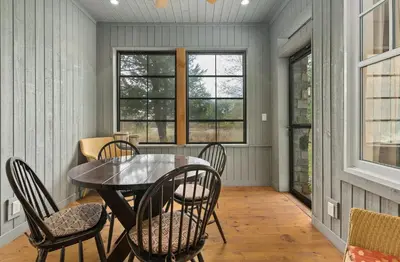 a dining room with a table and chairs and windows at Lakeside at Rocky Crest Resort and Golf Club on Joseph Lake in Rosseau