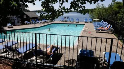 a pool with chairs and people in the water at Lakeside at Rocky Crest Resort and Golf Club on Joseph Lake in Rosseau