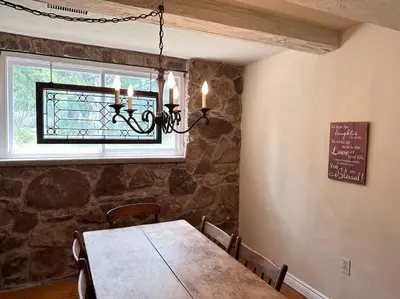 a dining room with a wooden table and a window at Cozie cottage at Niagara-On-The-Lake in Queenston
