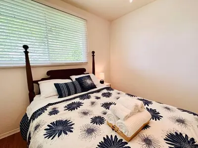 a bedroom with a bed with a blue and white comforter at Cozie cottage at Niagara-On-The-Lake in Queenston