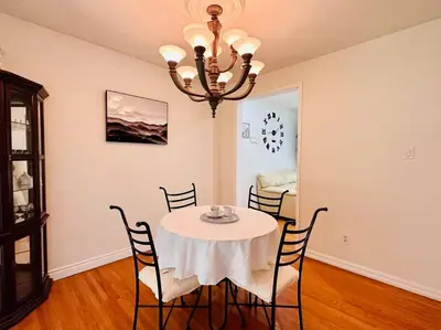 a dining room with a table with chairs and a chandelier at Cozie cottage at Niagara-On-The-Lake in Queenston