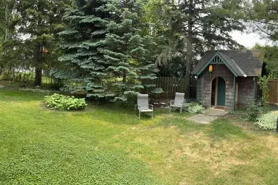 a small shed with two chairs in a yard at Cozie cottage at Niagara-On-The-Lake in Queenston