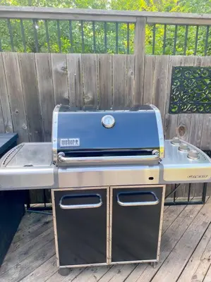 a grill sitting on a deck next to a fence at The Victoria Suite in Elora- King Bed in Elora