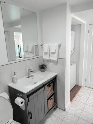 a white bathroom with a sink and a mirror at The Victoria Suite in Elora- King Bed in Elora
