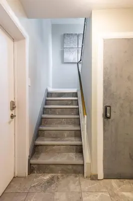 a hallway with stairs leading to a door at ENTIRE BACHELOR UNIT EN-SUITE UPTOWN WATERLOO - e4 in Waterloo