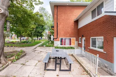 a picnic table in front of a brick building at ENTIRE BACHELOR UNIT EN-SUITE UPTOWN WATERLOO - e4 in Waterloo