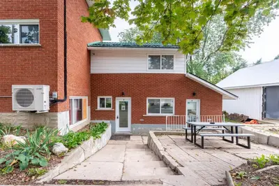 a brick house with a picnic table in front of it at ENTIRE BACHELOR UNIT EN-SUITE UPTOWN WATERLOO - e4 in Waterloo