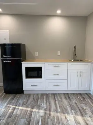 a kitchen with white cabinets and a black refrigerator at ENTIRE 2 BEDROOM APARTMENT DOWNTOWN - u5 in Waterloo