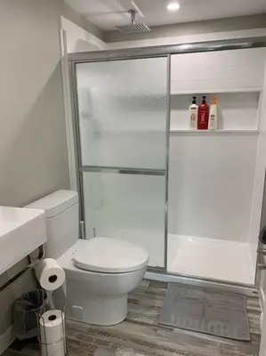 a bathroom with a toilet and a glass shower at ENTIRE 2 BEDROOM APARTMENT DOWNTOWN - u5 in Waterloo