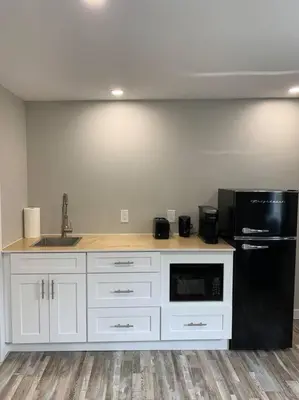 a kitchen with white cabinets and a black refrigerator at ENTIRE 1 BEDROOM APARTMENT DOWNTOWN - u4 in Waterloo