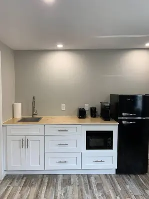 a kitchen with white cabinets and a black refrigerator at ENTIRE 1 BEDROOM APARTMENT DOWNTOWN - u4 in Waterloo