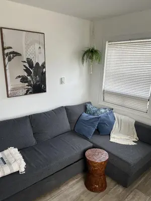 a living room with a gray couch with blue pillows at Casa Di Nonna in Wasaga Beach