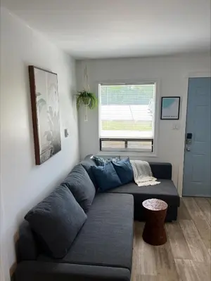 a living room with a blue couch and a window at Casa Di Nonna in Wasaga Beach