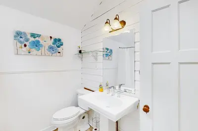 a white bathroom with a sink and a toilet at Mary Jane's Cottage in Crystal Beach