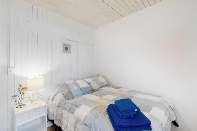 a bedroom with a bed with blue towels on it at Mary Jane's Cottage in Crystal Beach