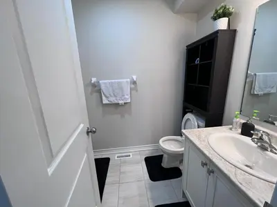 a white bathroom with a sink and a toilet at New Kleinburg Towns in Woodbridge