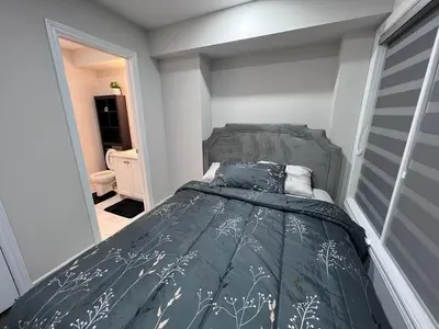 a bedroom with a bed with a gray comforter at New Kleinburg Towns in Woodbridge
