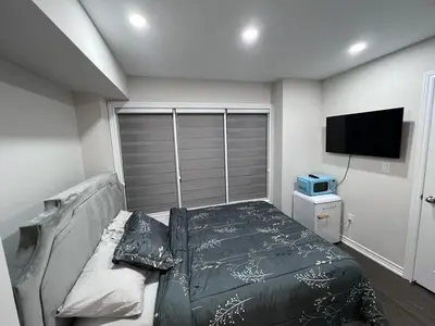 a bedroom with a bed and a flat screen tv at New Kleinburg Towns in Woodbridge