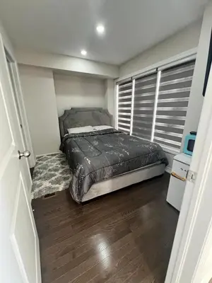 a bedroom with a bed and a wooden floor at New Kleinburg Towns in Woodbridge