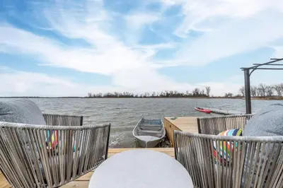 a boat on the water with chairs on a dock at The Birch in Wellington
