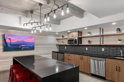 a kitchen with a black counter top and wooden cabinets at Cannery Lofts Niagara in Niagara Falls
