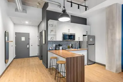 a kitchen with a counter and stools in it at Cannery Lofts Niagara in Niagara Falls