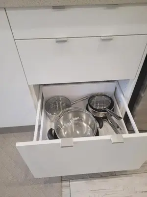 a drawer with four pots and pans in a kitchen at Modern studio with kitchenette and bath in Guelph