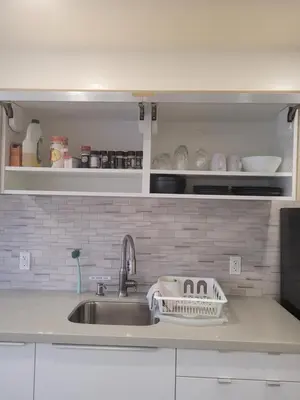 a kitchen sink with a dish drying rack next to it at Modern studio with kitchenette and bath in Guelph