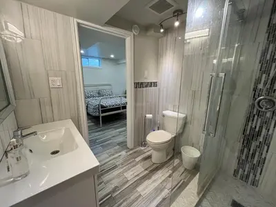 a bathroom with a toilet and a shower and a sink at Modern studio with kitchenette and bath in Guelph