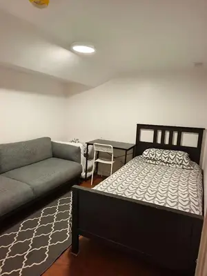 a living room with a bed and a couch at BASEMEWNT Room with private bathroom 36C in Toronto