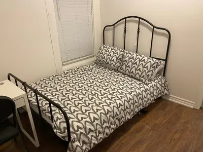a bed with a black frame and a pillow at BUDGET Quad Room with En Suite Bathroom 36B in Toronto
