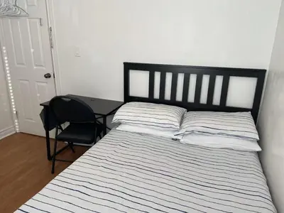a bedroom with a bed with a chair and a desk at Double Room with SHARED Bathroom 536B in Toronto