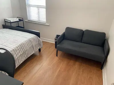 a living room with a couch and a bed at Double Room with SHARED Bathroom 536B in Toronto