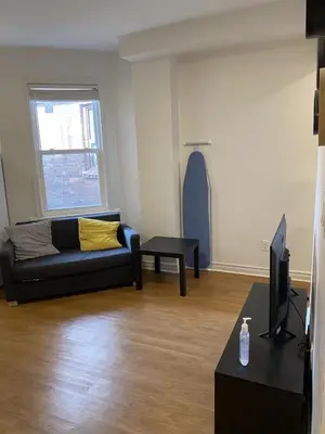 a living room with a couch and a tv at Double Room with SHARED Bathroom 536B in Toronto
