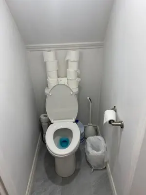 a small bathroom with a toilet with a bunch of towels at Double Room with SHARED Bathroom 536B in Toronto