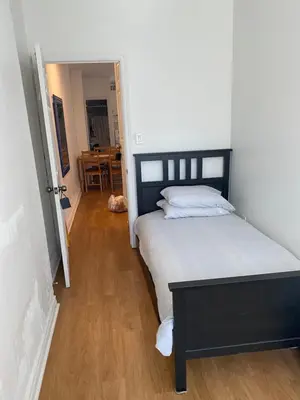 a bedroom with a large bed and a wooden floor at Single Room with SHARED Bathroom 536C in Toronto