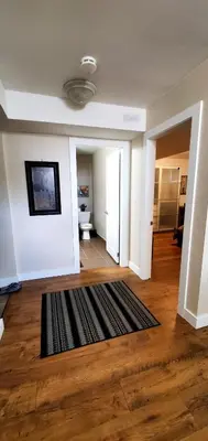a living room with a black rug on a wooden floor at Spacious Guest Suite in Hamilton