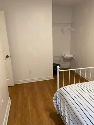 a bedroom with a bed and a wooden floor at Quad Room with Private Bathroom 536A-Two Bedrooms in Toronto