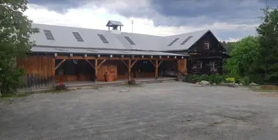 a large wooden barn with a white roof at Burnt River Bungalow in Kinmount