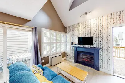 a living room with a blue couch and a fireplace at Condo 612 at North Creek Resort in Blue Mountains