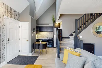 a living room with a couch and a stairway at Condo 612 at North Creek Resort in Blue Mountains