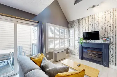 a living room with a couch and a fireplace at Condo 612 at North Creek Resort in Blue Mountains