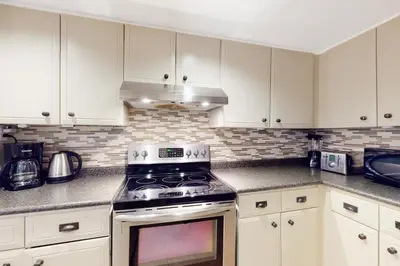 a kitchen with white cabinets and a stove top oven at Sierra Lane 105 in Blue Mountains