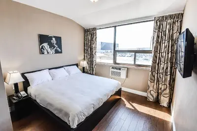 a small bedroom with a bed and a window at NU Hotel Toronto Airport in Mississauga