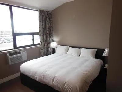 a bedroom with a large white bed with a window at NU Hotel Toronto Airport in Mississauga