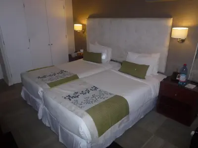 a bedroom with a large white bed with green pillows at NU Hotel Toronto Airport in Mississauga