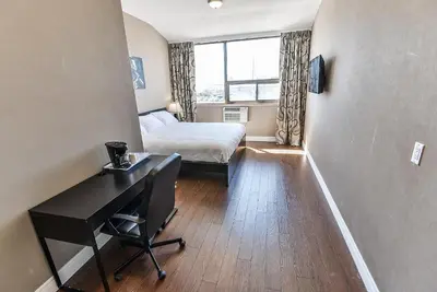 a small room with a bed and a desk in it at NU Hotel Toronto Airport in Mississauga