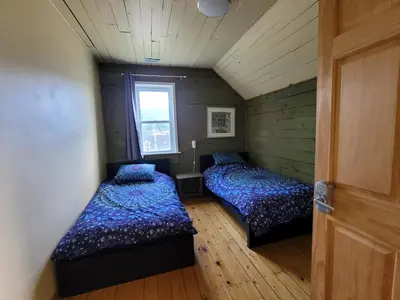 two beds in a small room with a window at 23Maple in Haliburton